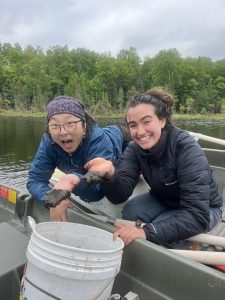 Two woman in a boat hold sediment samples they collected. 